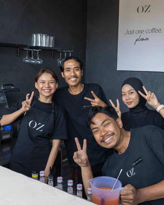 Four of the OZ team behind the bar, smiling.