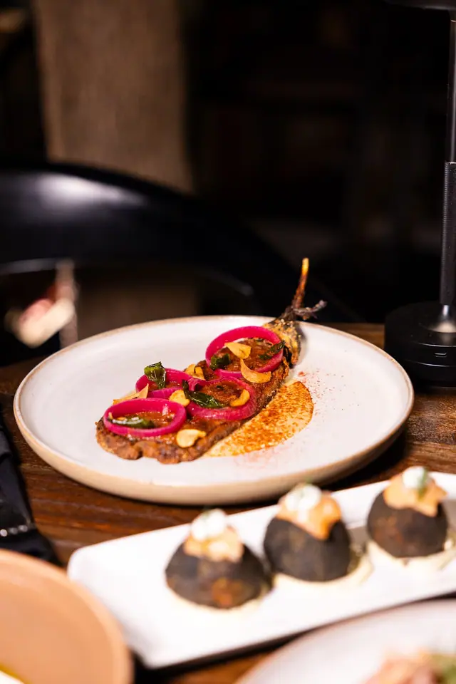 Une aubergine croustillante aux oignons marinés.