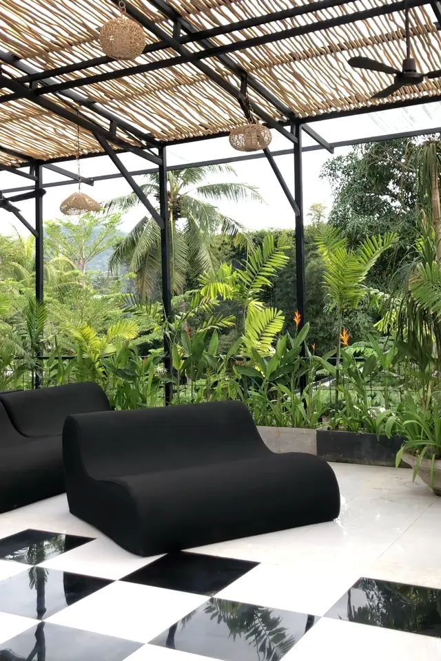 À l’étage, au bord : deux fauteuils lounge avec vue sur les palmiers.