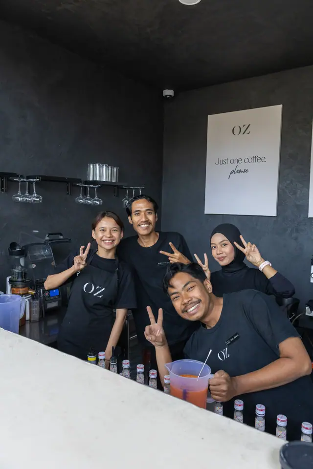 Quatre membres de l’équipe OZ derrière le bar, tout sourire.