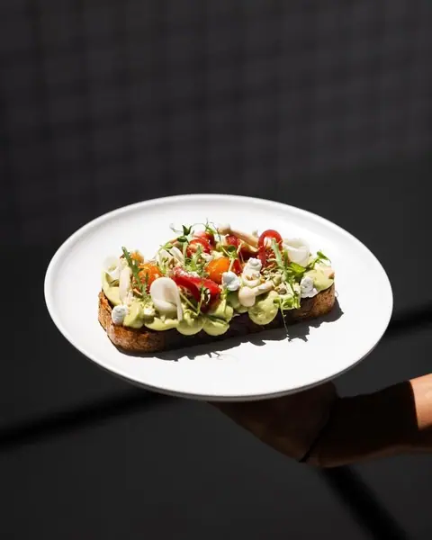Sourdough toast with smashed avocado, confit tomato and crumbled feta.