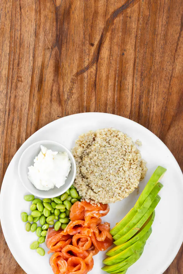 Une assiette à composer vue du dessus : quinoa, saumon fumé, avocat et edamame.
