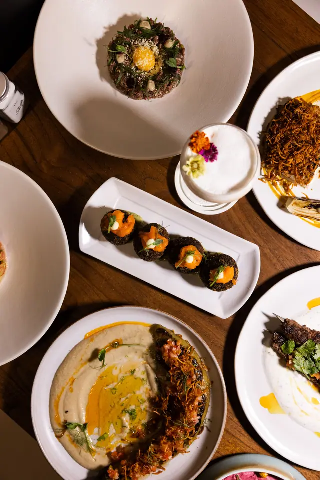 La table du dîner vue du dessus : mezze, arancini et tartare.