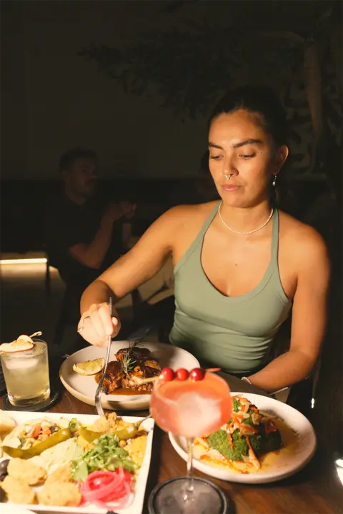 Une cliente savoure son dîner, le soir.