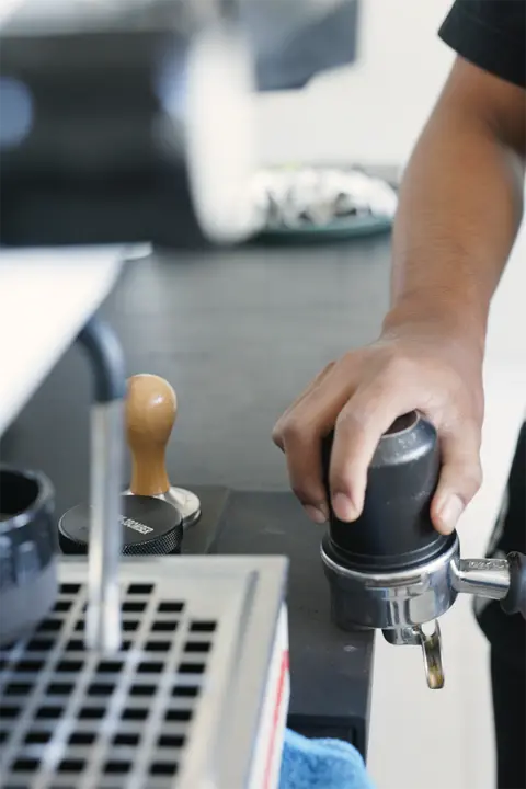 Un barista tasse le café frais au bar.